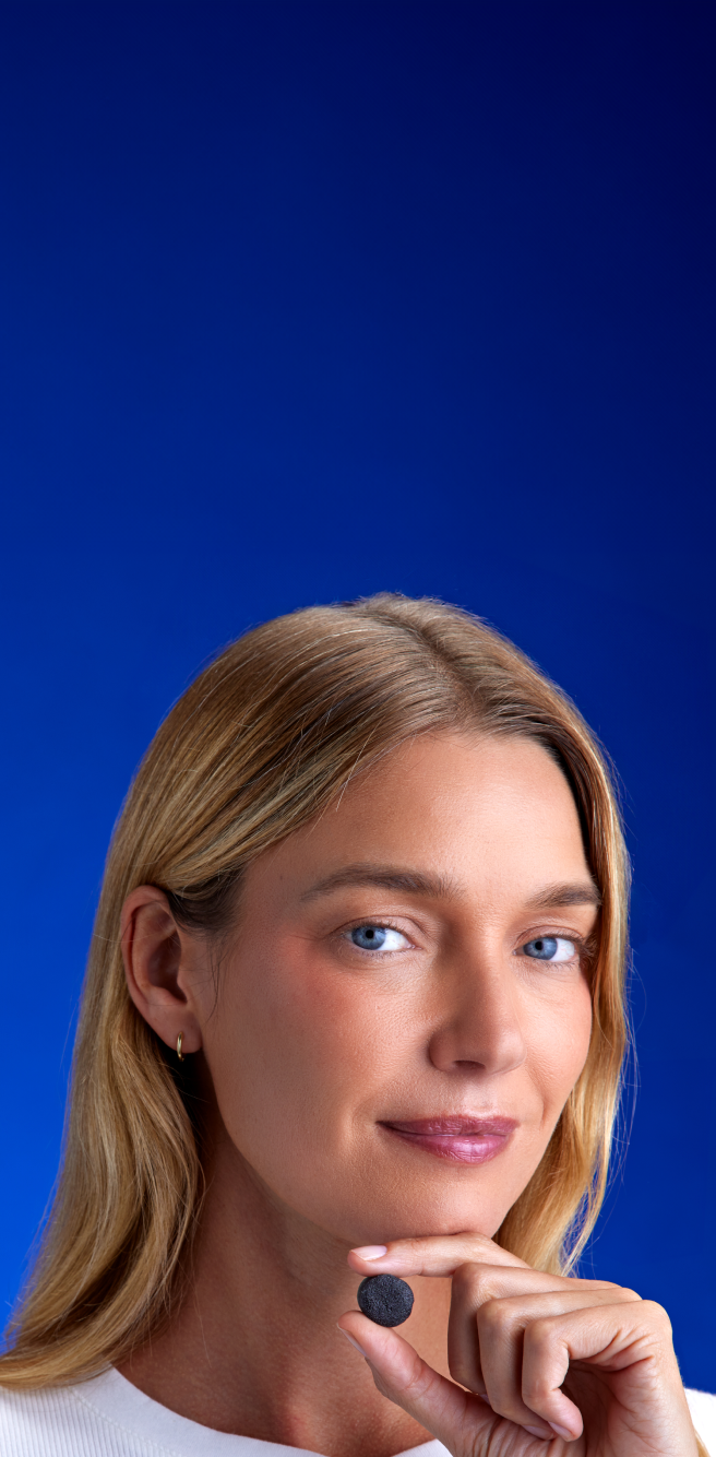 FOCL wellness supplement bottle held by a smiling user - promotes better sleep, calm, and focus.