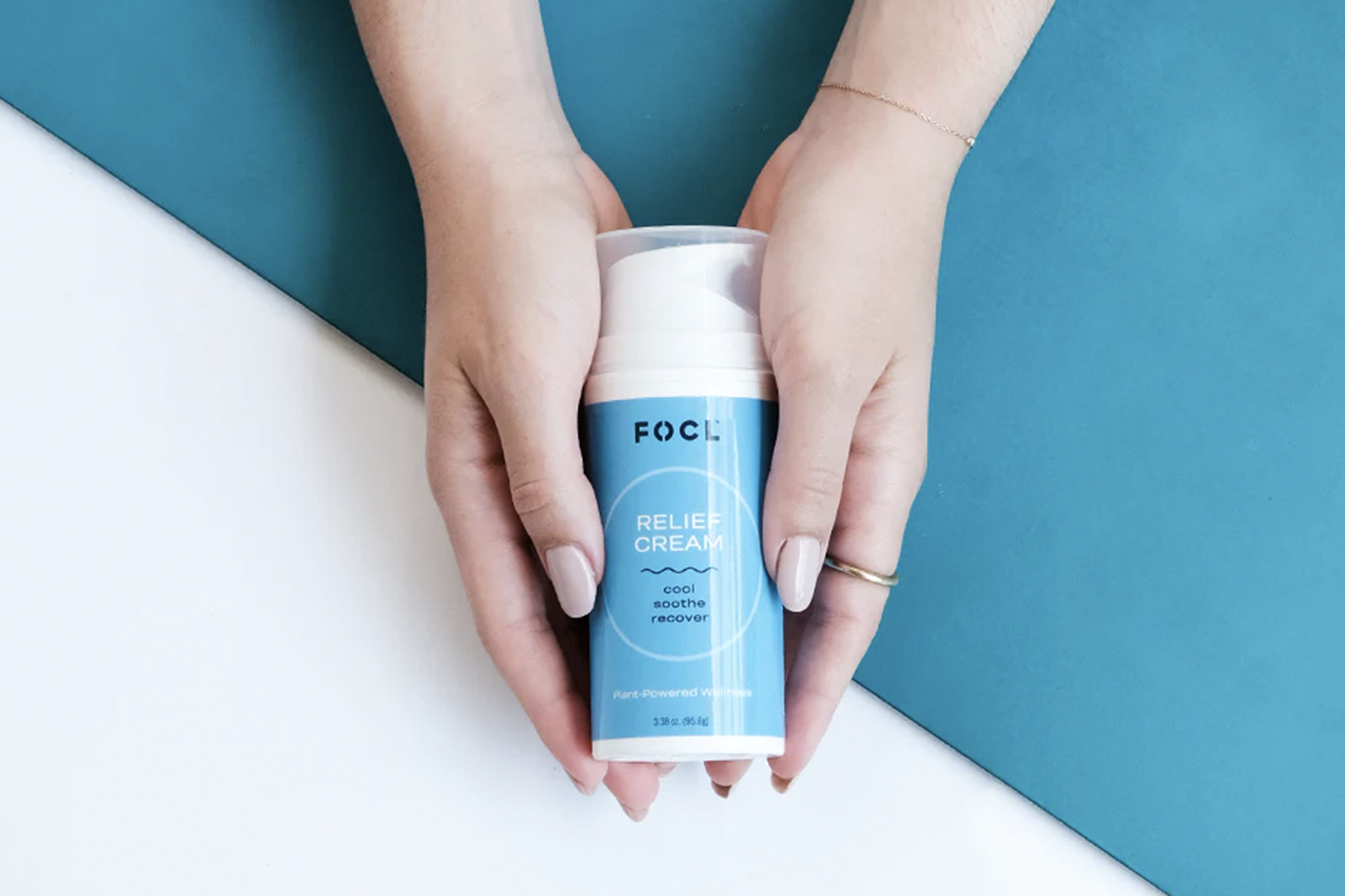 Woman's hands holding a bottle of FOCL Relief Cream.
