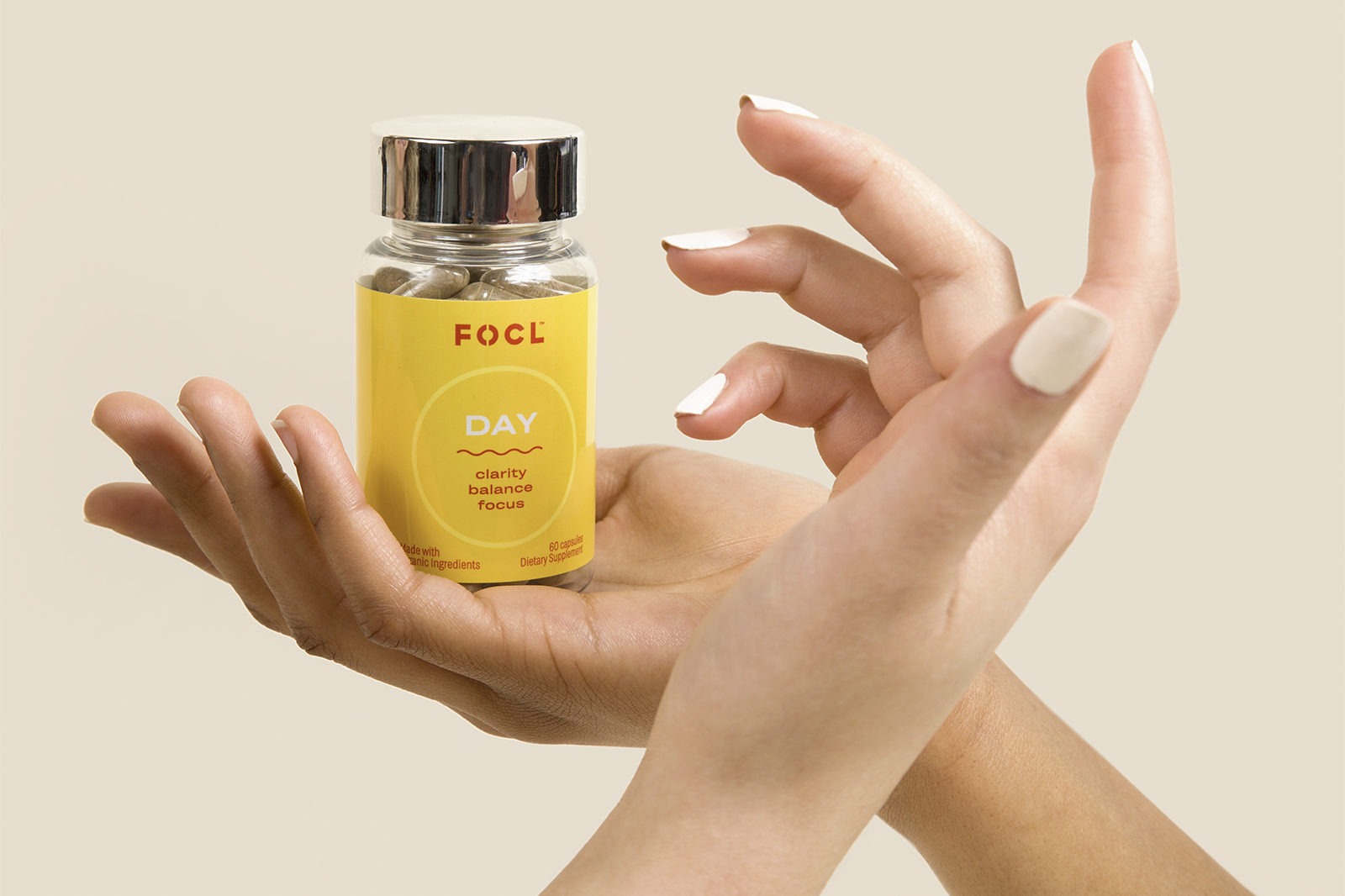 Woman's hands with a bottle of FOCL Day.