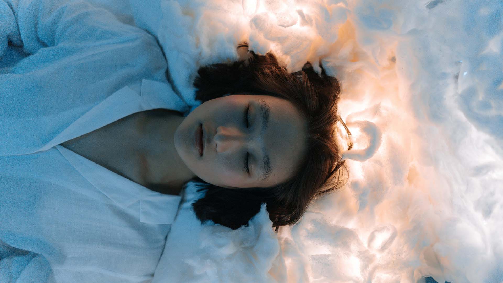 A woman asleep on a glowing cloud