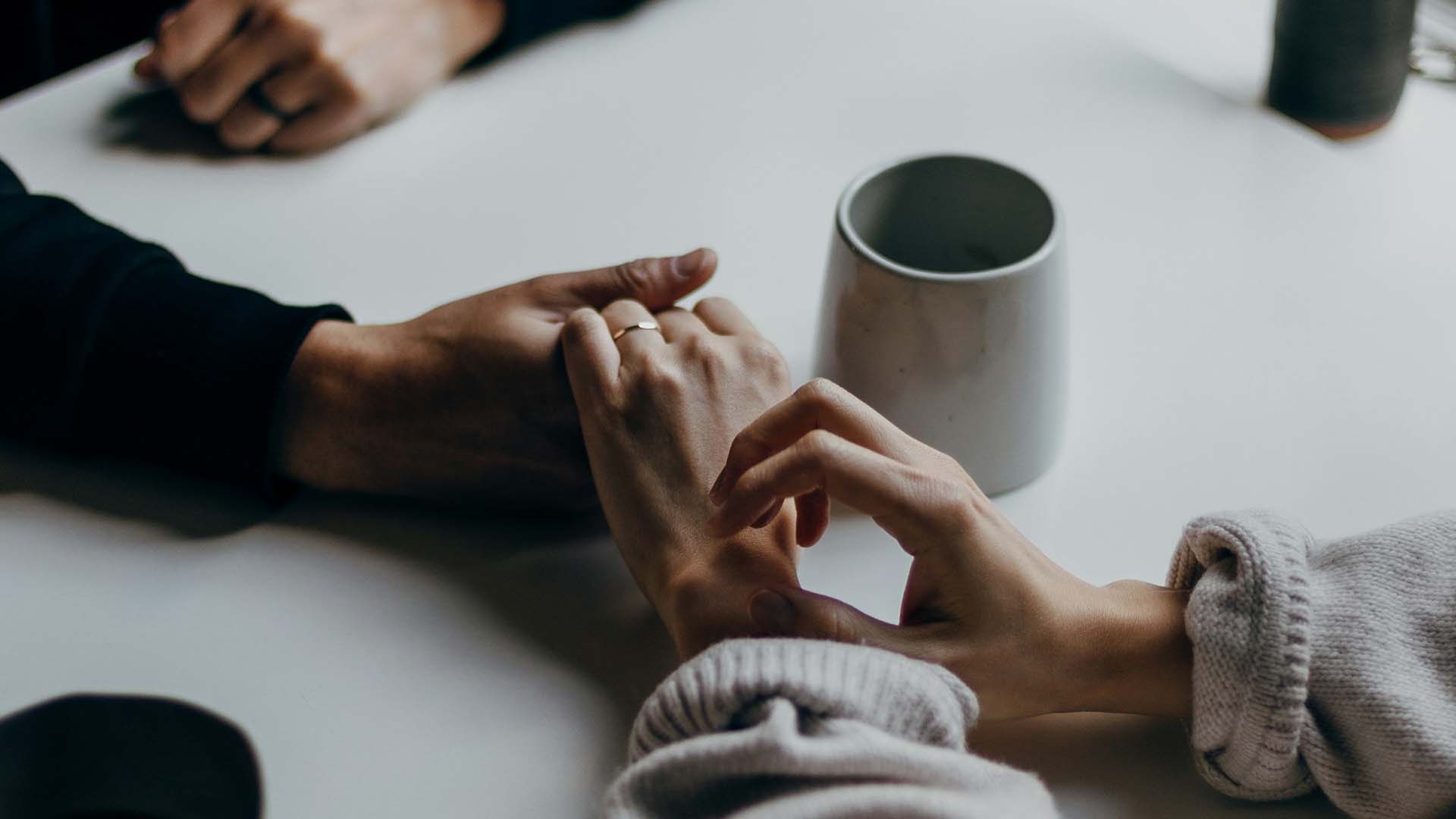 couple holding hands across the table