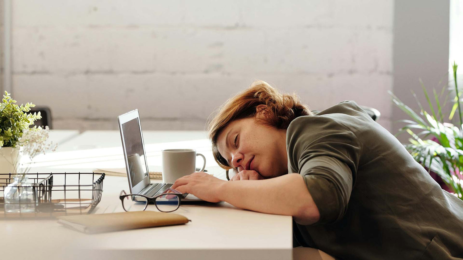 a woman sleeping on her desk 