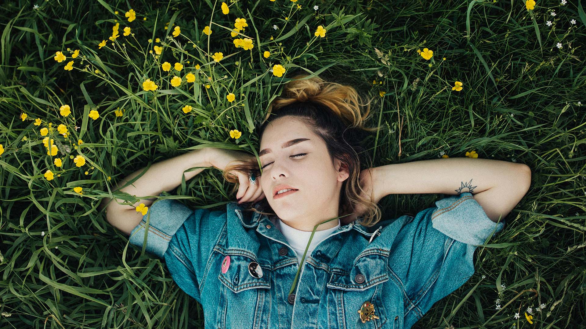 a young woman sleeping on grass