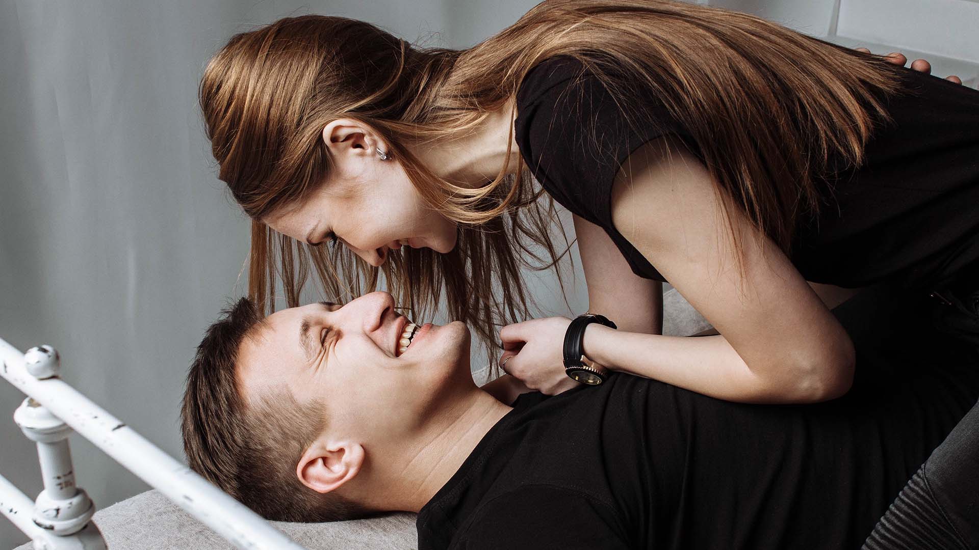 smiling man and woman in bed