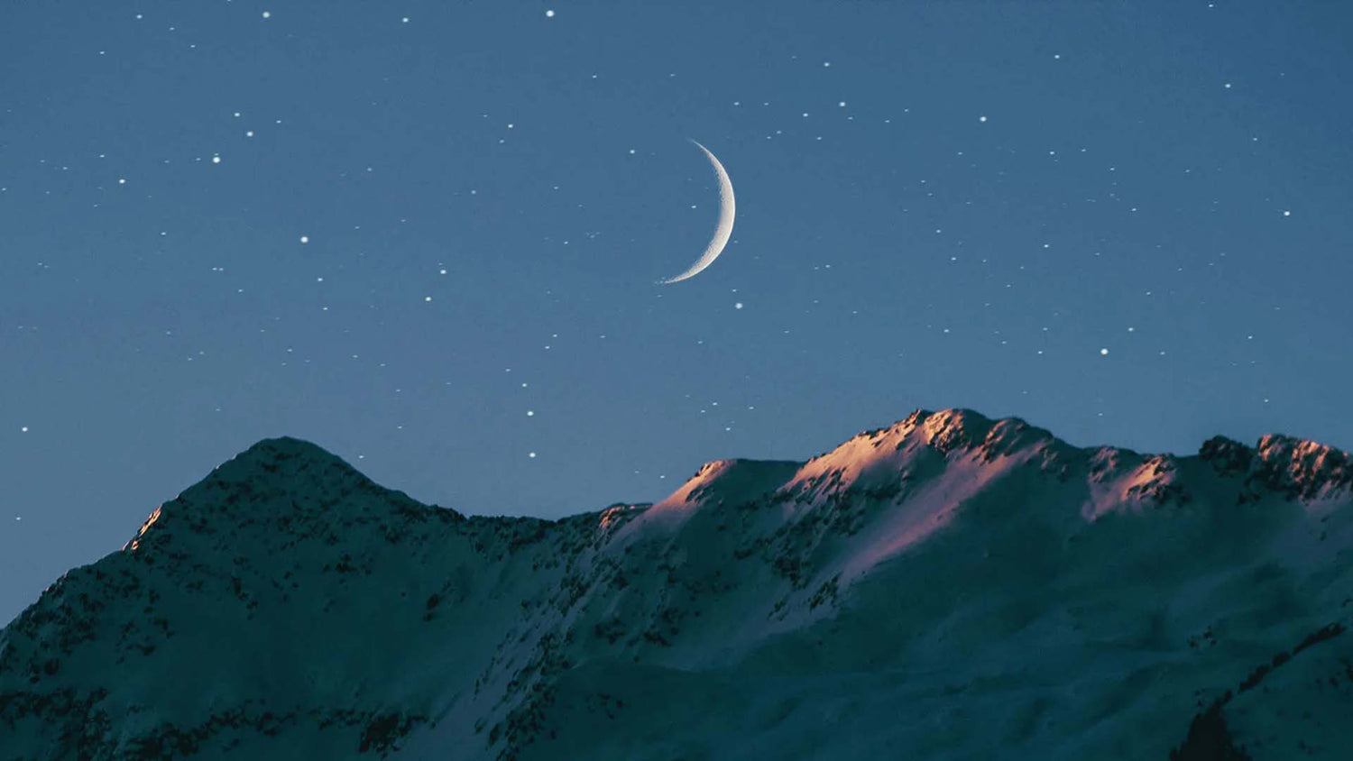 Crescent moon above mountain
