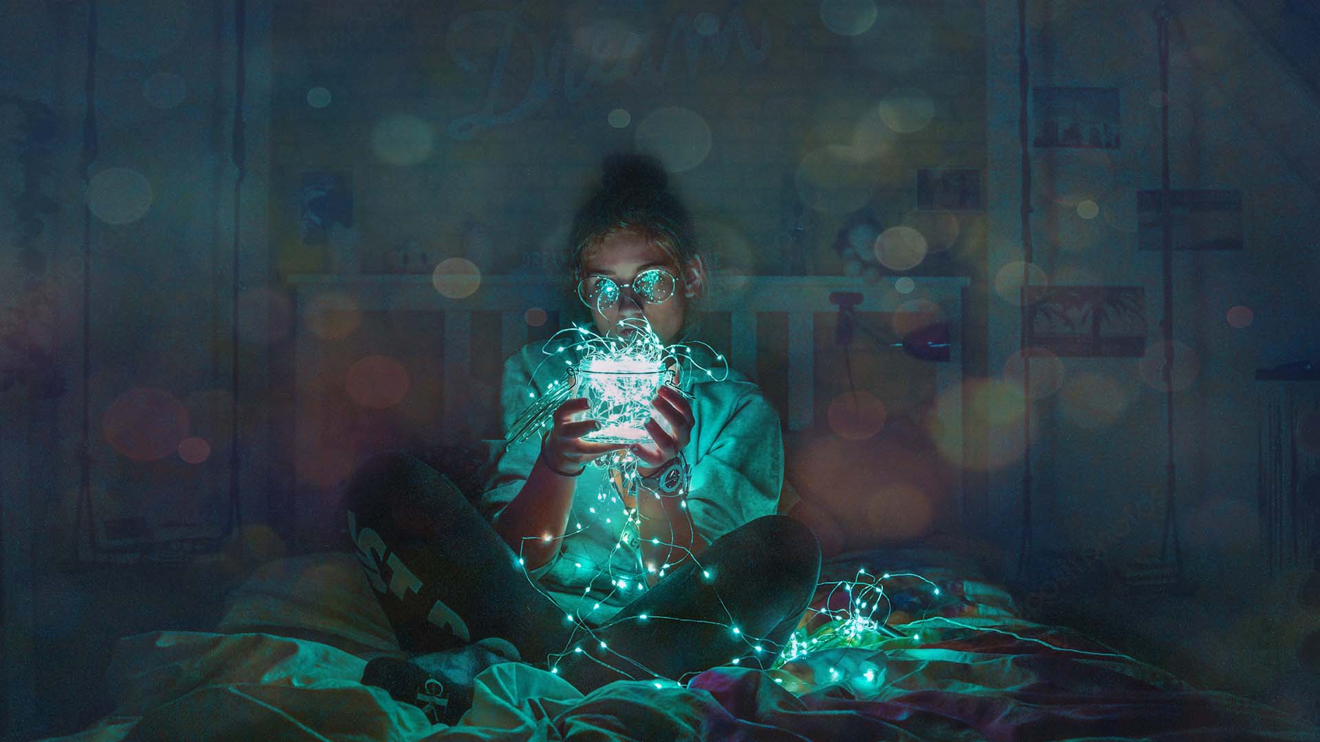 woman holding a green LED light while sitting on a bed