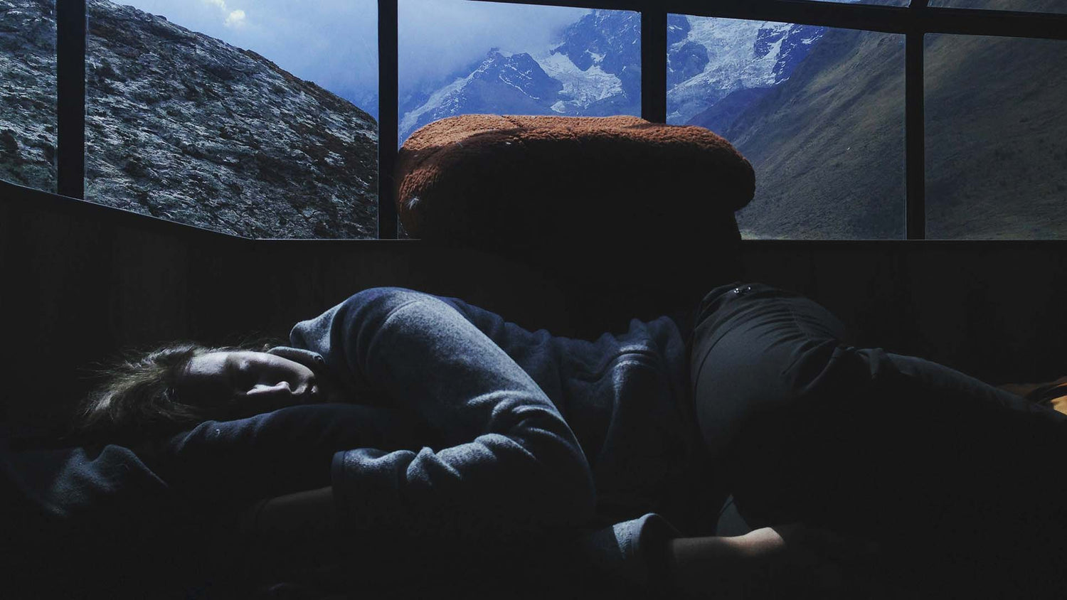 Sleeping person under window with mountain background