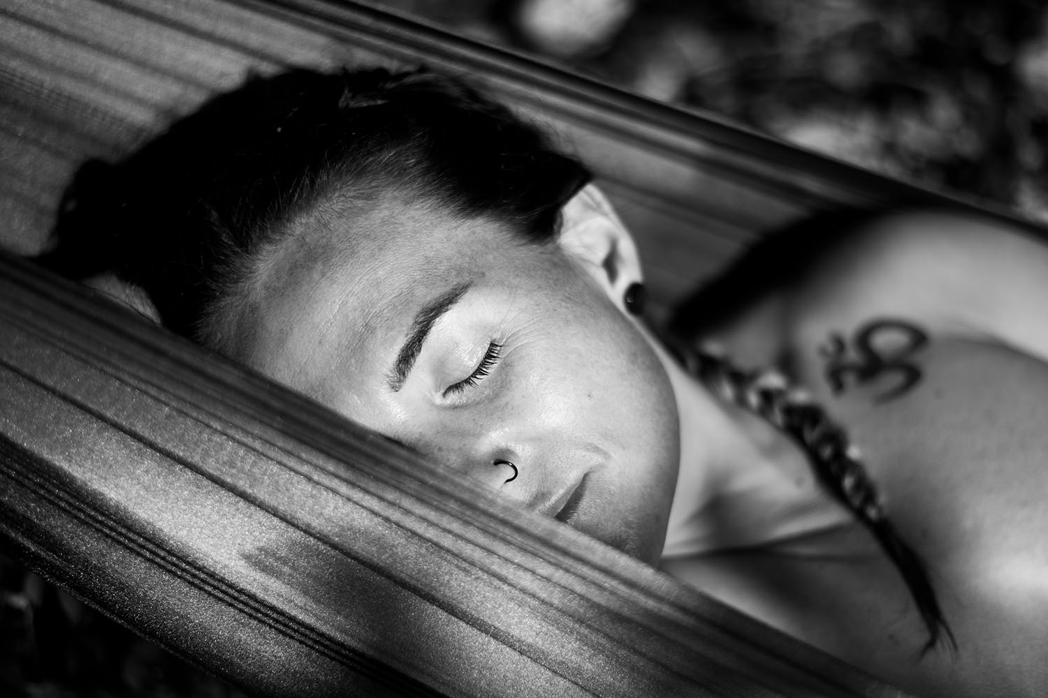 a woman laying in a hammock with her eyes closed